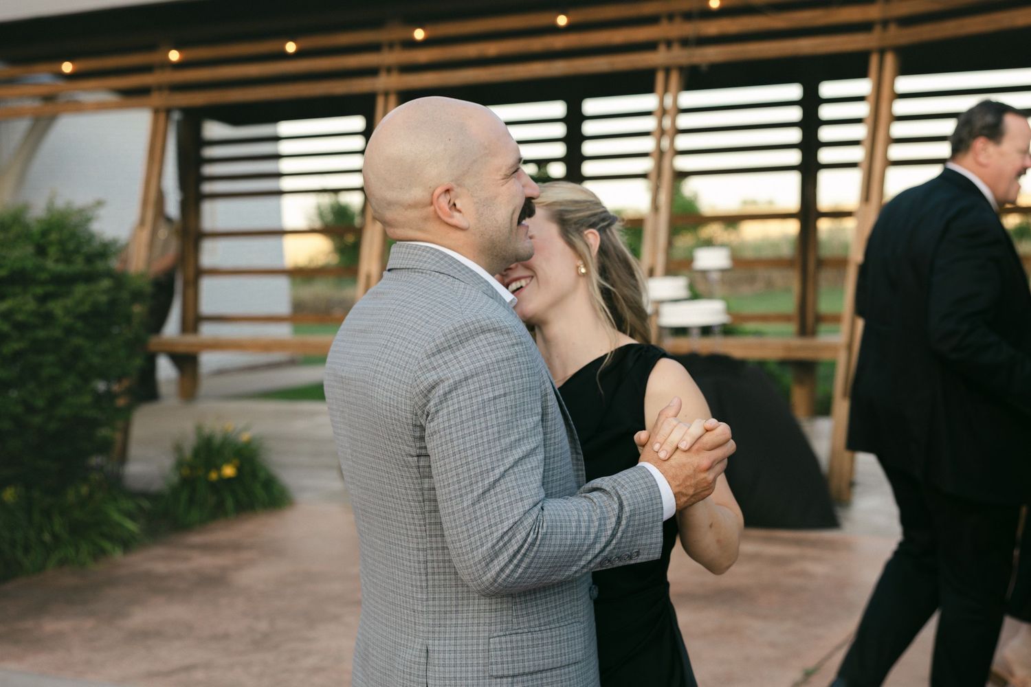 Couple sharing a romantic dance outdoors at an elegant wedding reception venue.