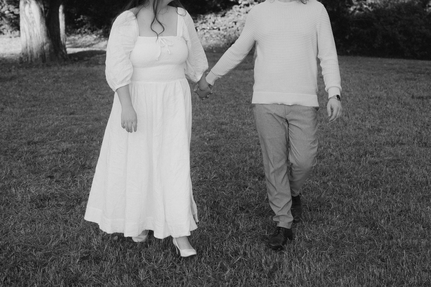 A series of black and white photographs showing a couple walking together outdoors in casual attire.