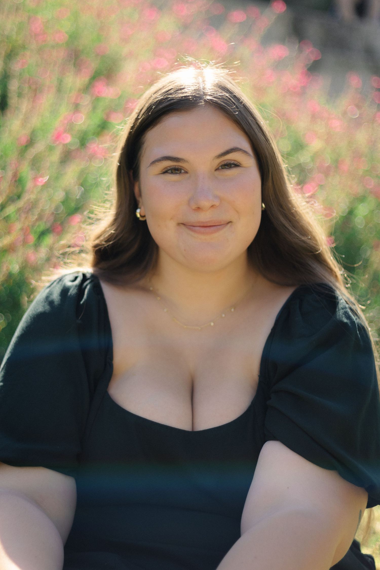 Portrait session in field with pink flowers during golden hour.