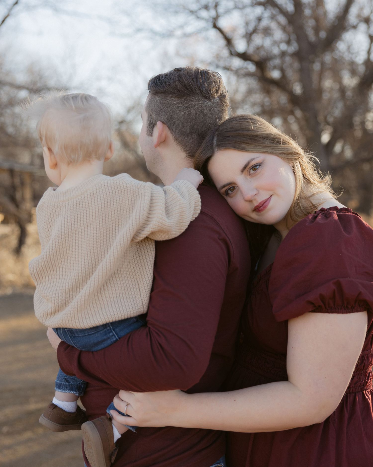 Family shares tender embraces in a series of candid moments captured outdoors during autumn.