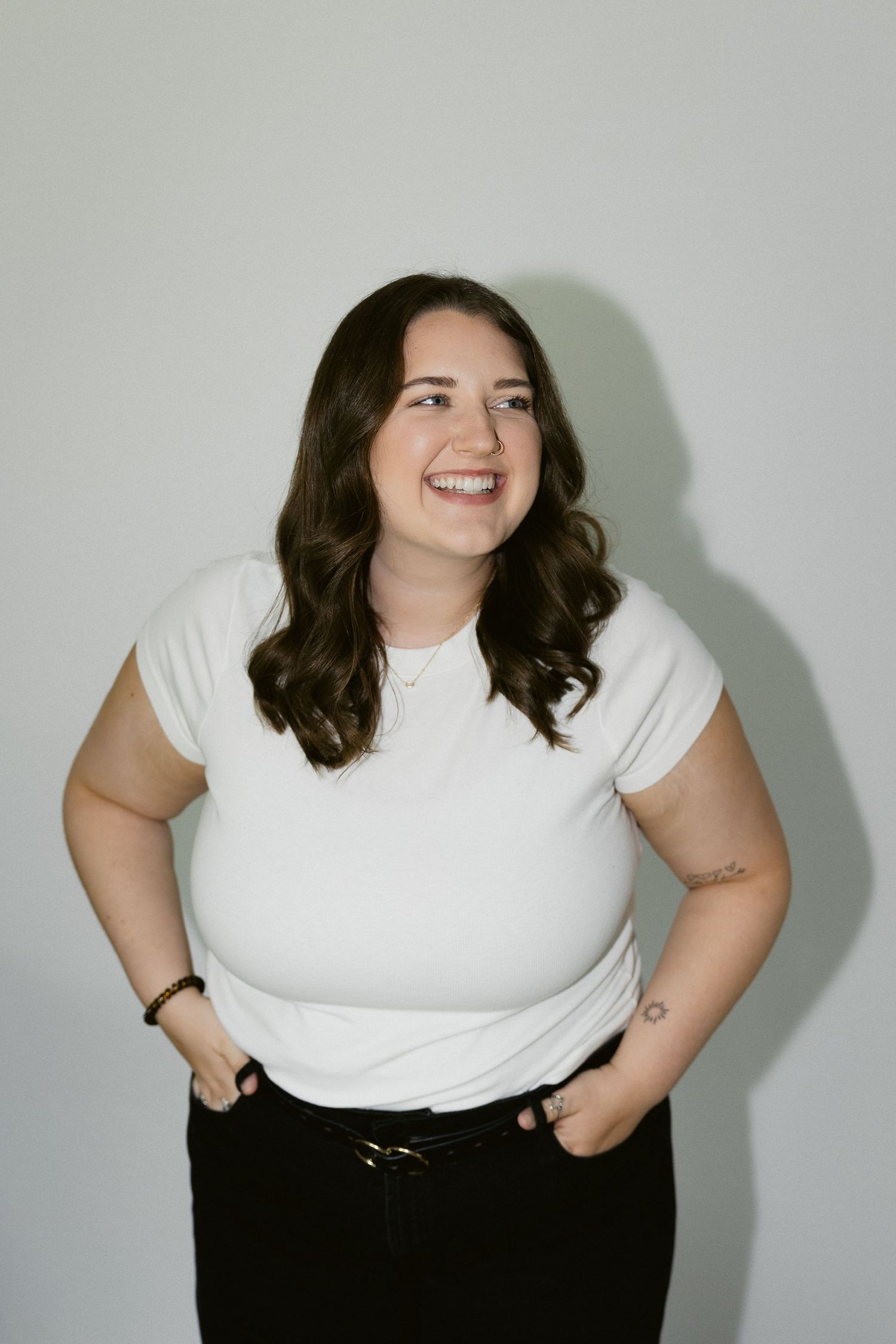 A series of fashion portraits showing someone in a white t-shirt and dark pants posing confidently against a light background.