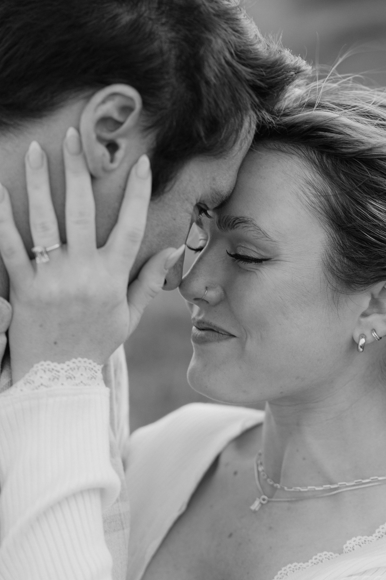 Black and white romantic photos showing tender moments between a couple on their wedding day.