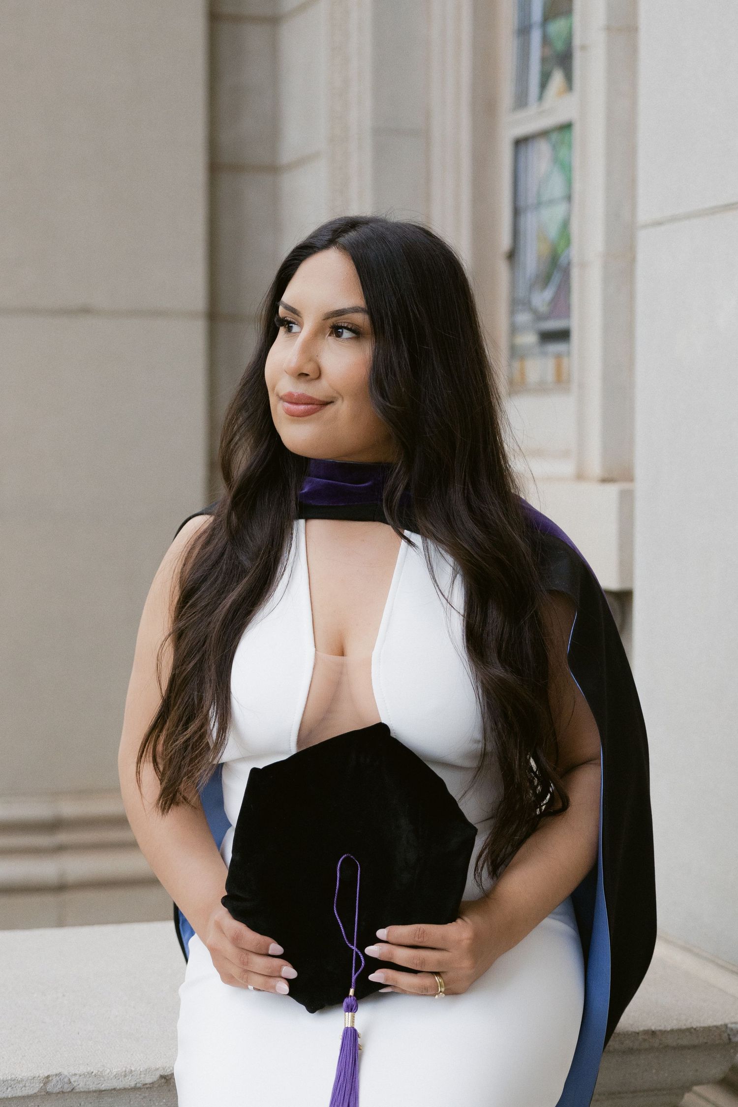 Woman in black and white outfits poses gracefully against architectural columns in a professional photo series.