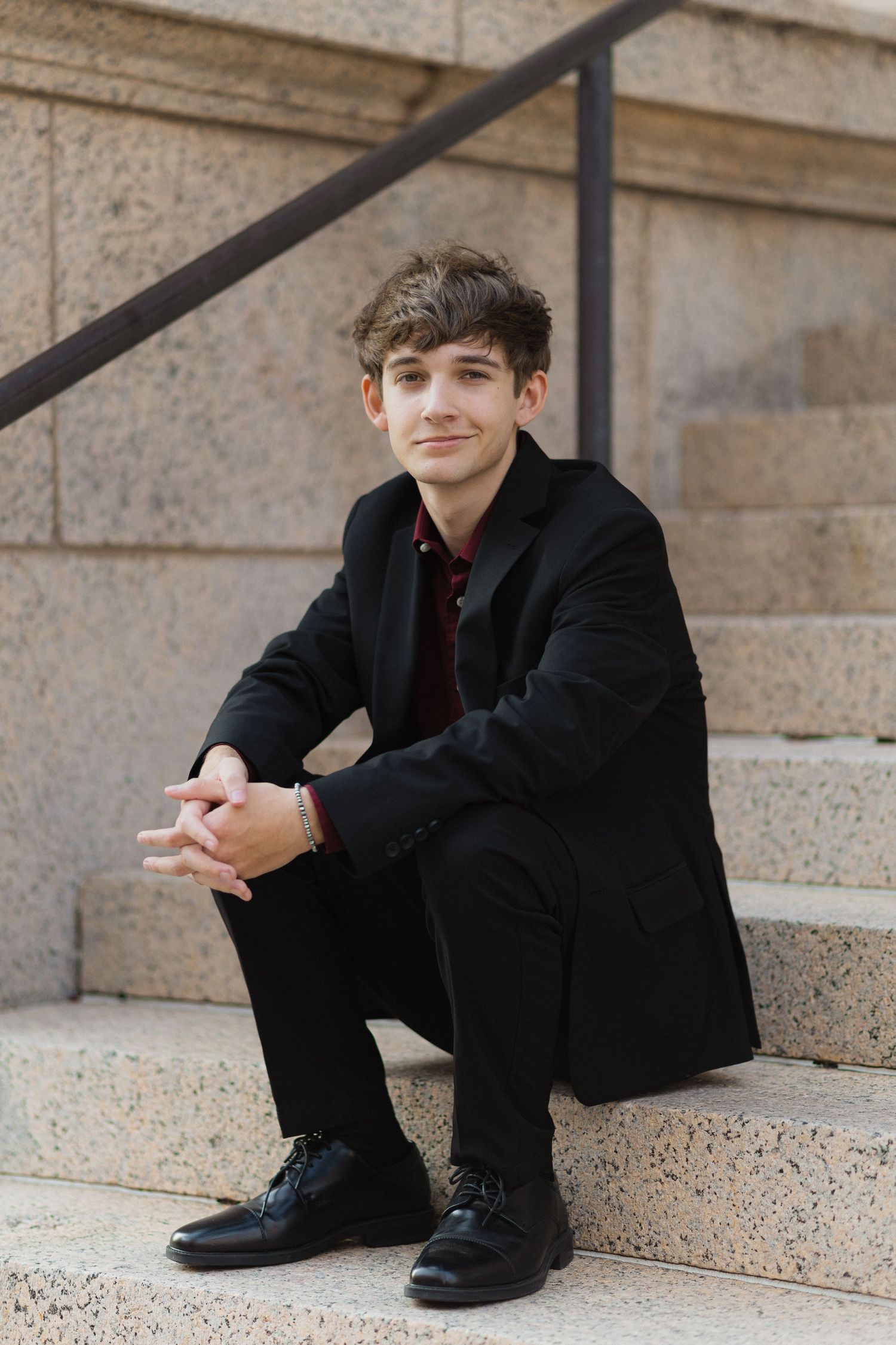 A series of artistic portraits showing a person in black attire sitting on concrete steps in different poses.