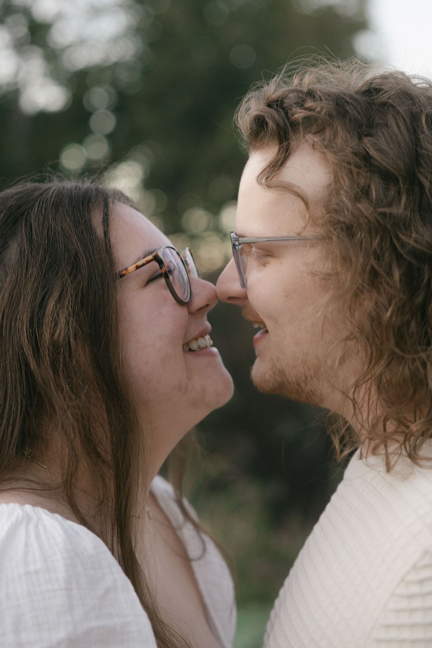 A romantic couple sharing intimate moments in a series of candid outdoor portraits.