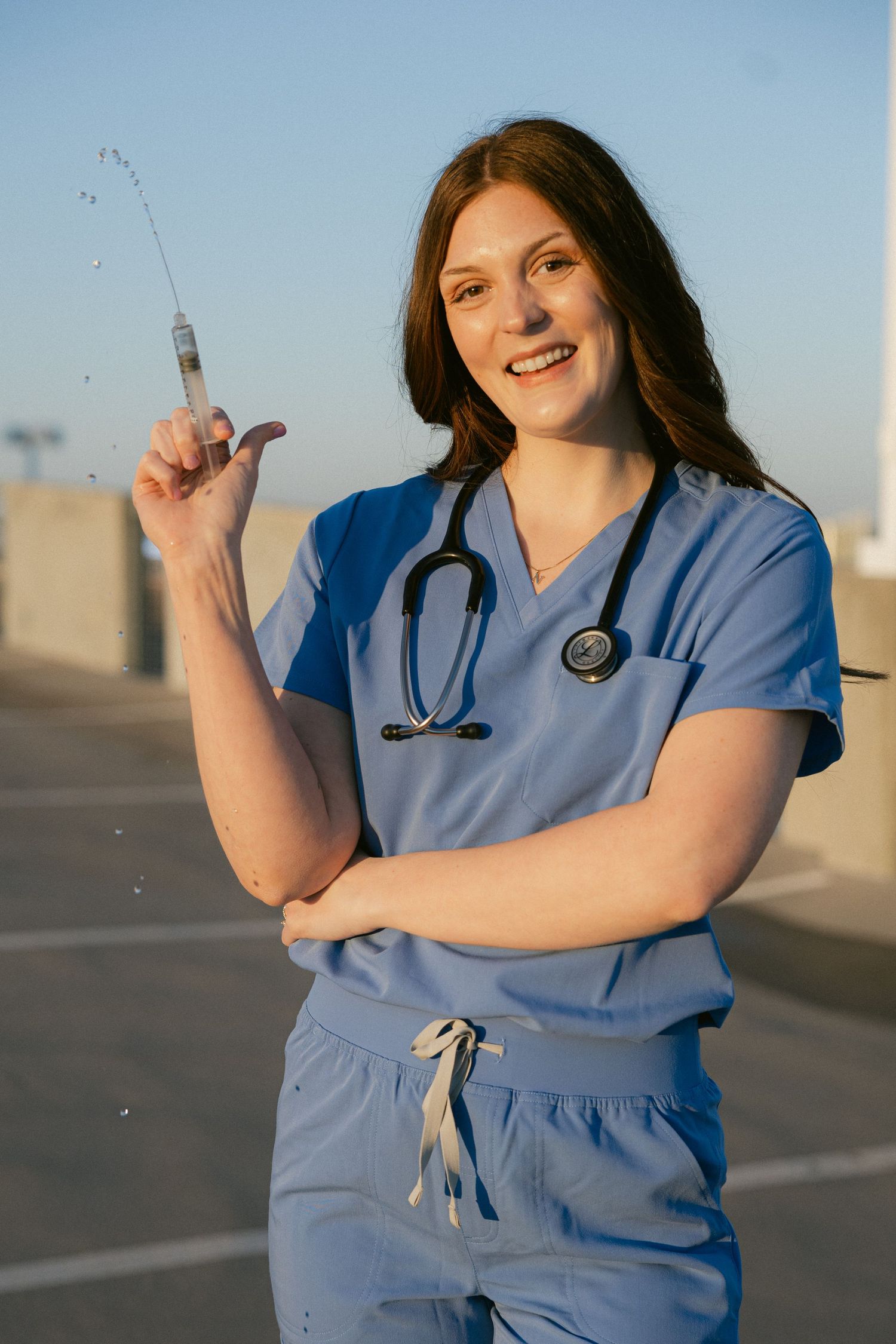 Healthcare worker in blue scrubs stands outdoors holding medical supplies in a series of expressive poses.