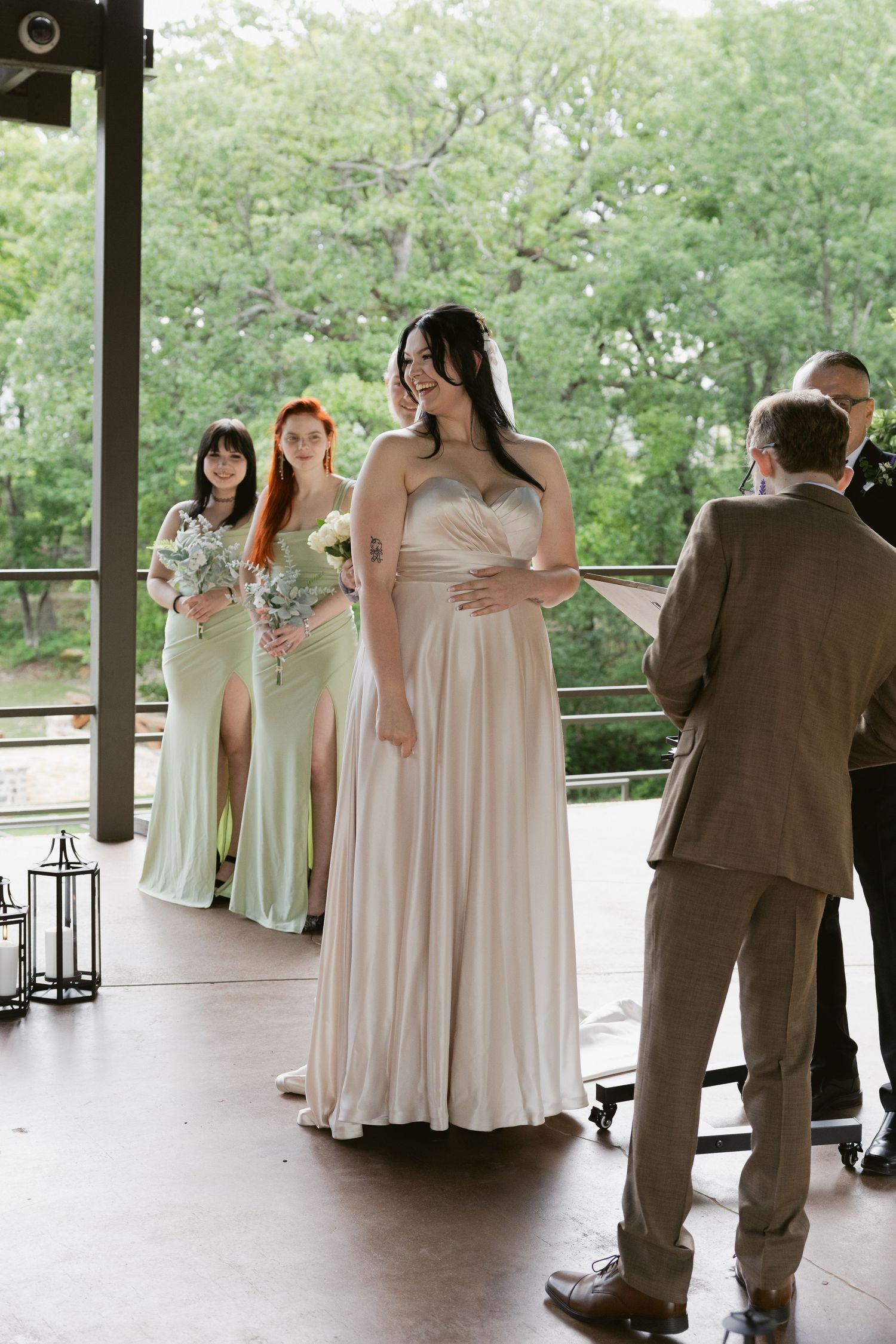 Wedding party gathering on a covered outdoor porch surrounded by greenery.