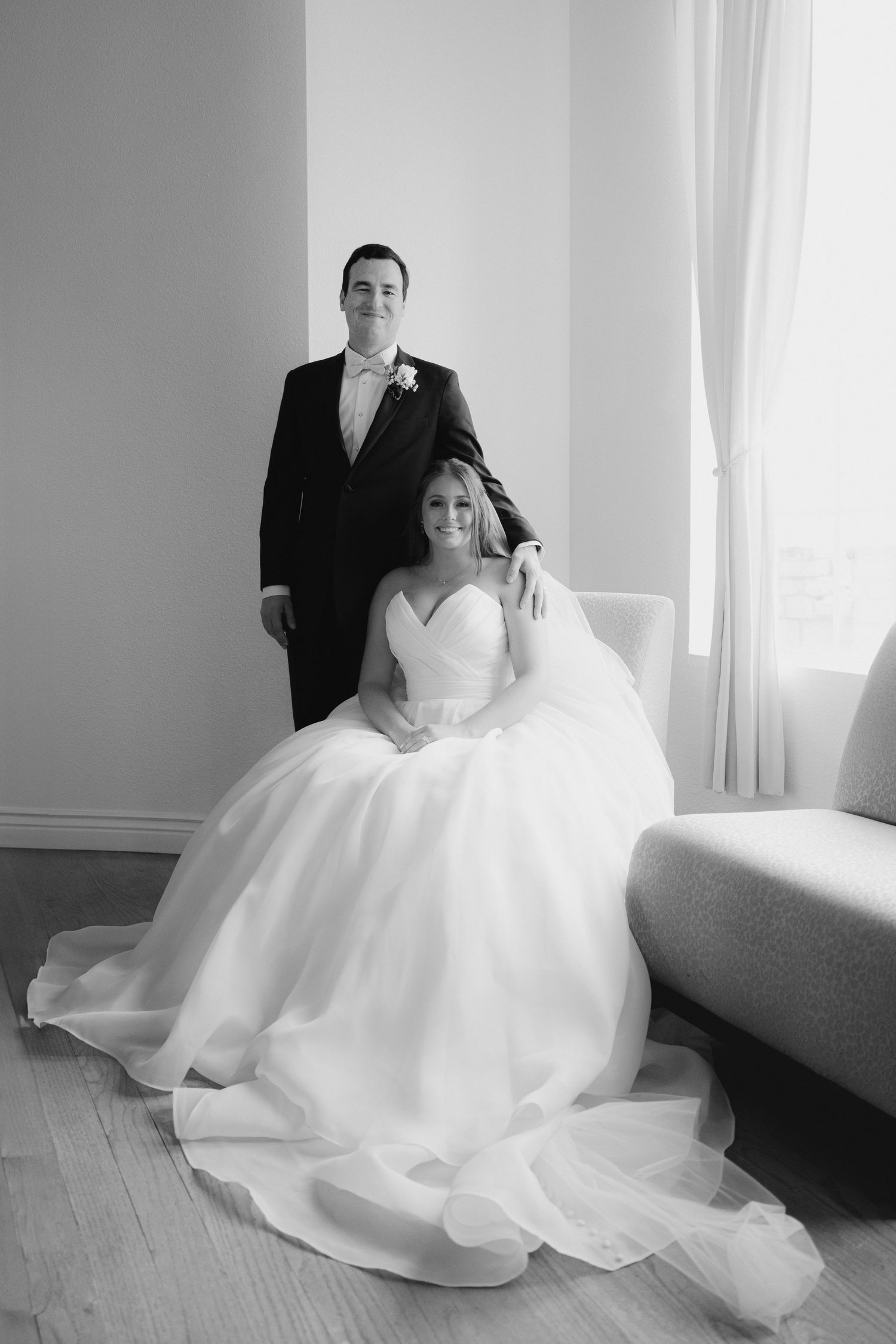 Elegant wedding portraits in a bright room with flowing white gown and natural window light.