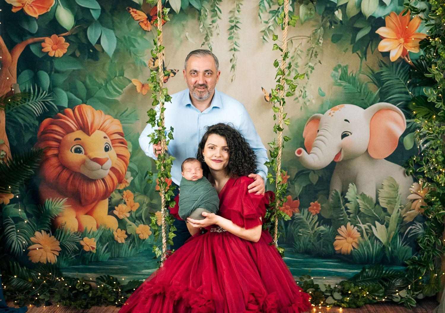 Family portrait with newborn on jungle-themed swing set backdrop featuring lion and elephant illustrations.