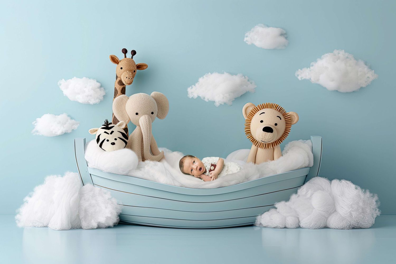 Newborn baby sleeping in a small boat with stuffed animal toys giraffe elephant zebra and lion on blue background.