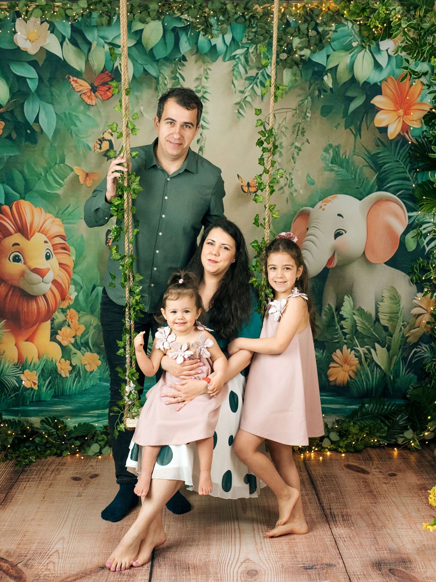 Family of four posing on a swing with a tropical jungle backdrop featuring a lion and elephant.