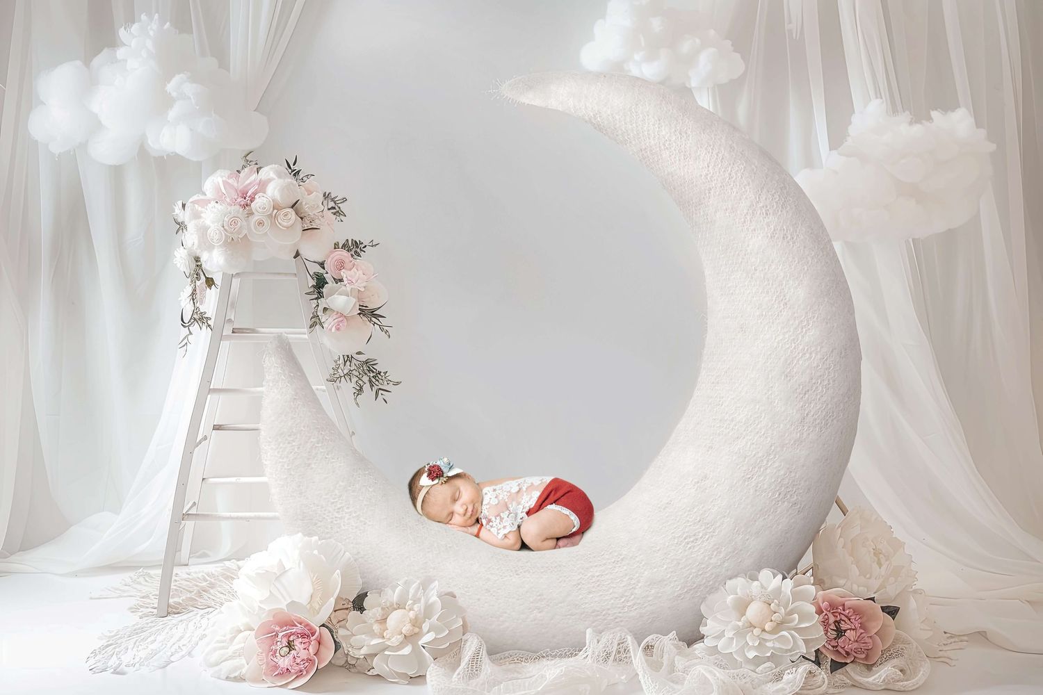 Newborn baby sleeping on white crescent moon prop with pink flowers and ladder in dreamy studio photo.