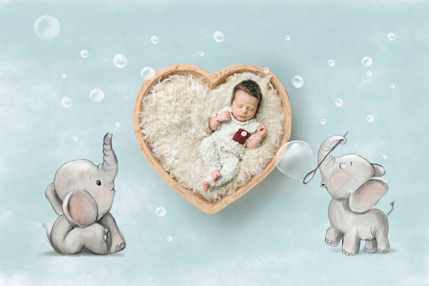 Newborn baby sleeping in heart-shaped wooden bowl surrounded by cartoon elephants and bubbles on soft blue background.