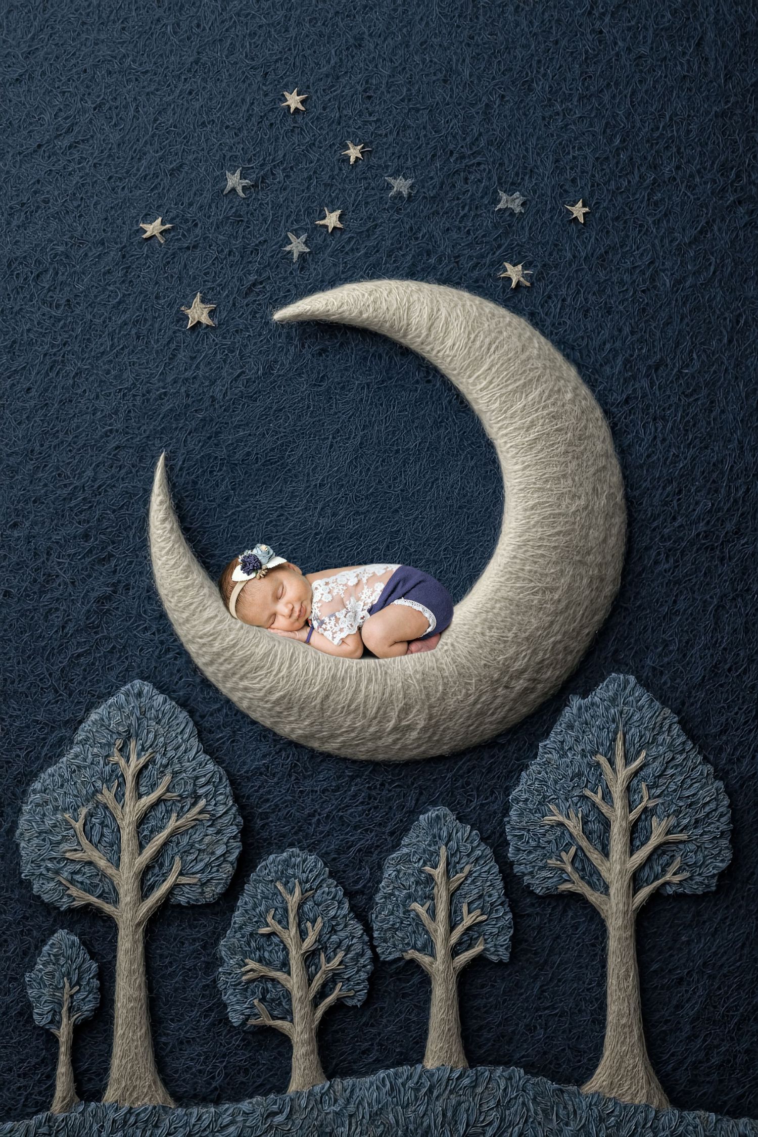 Newborn baby sleeping peacefully on a crescent moon with trees and stars in a dreamy night sky backdrop.