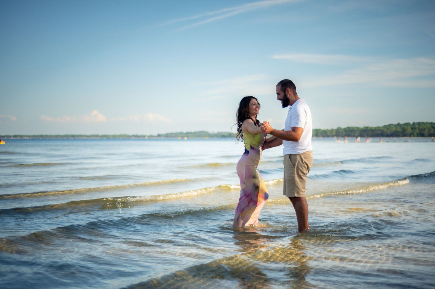 Couple amoureux marchant dans l’eau lors d’une séance engagement à Biscarrosse