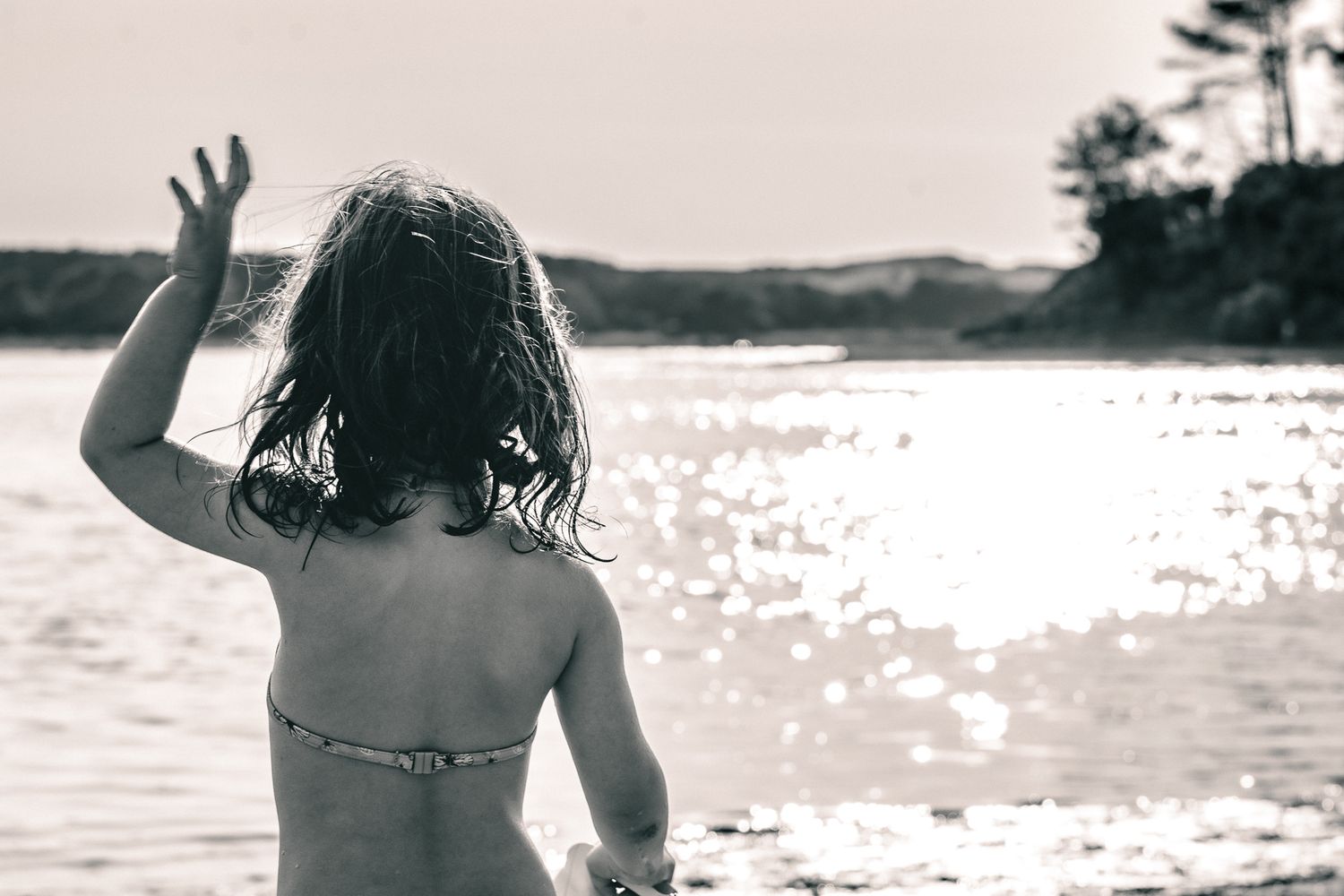 Petite fille de dos au bord de l'eau à Vieux-Boucau-les-Bains, dans les Landes