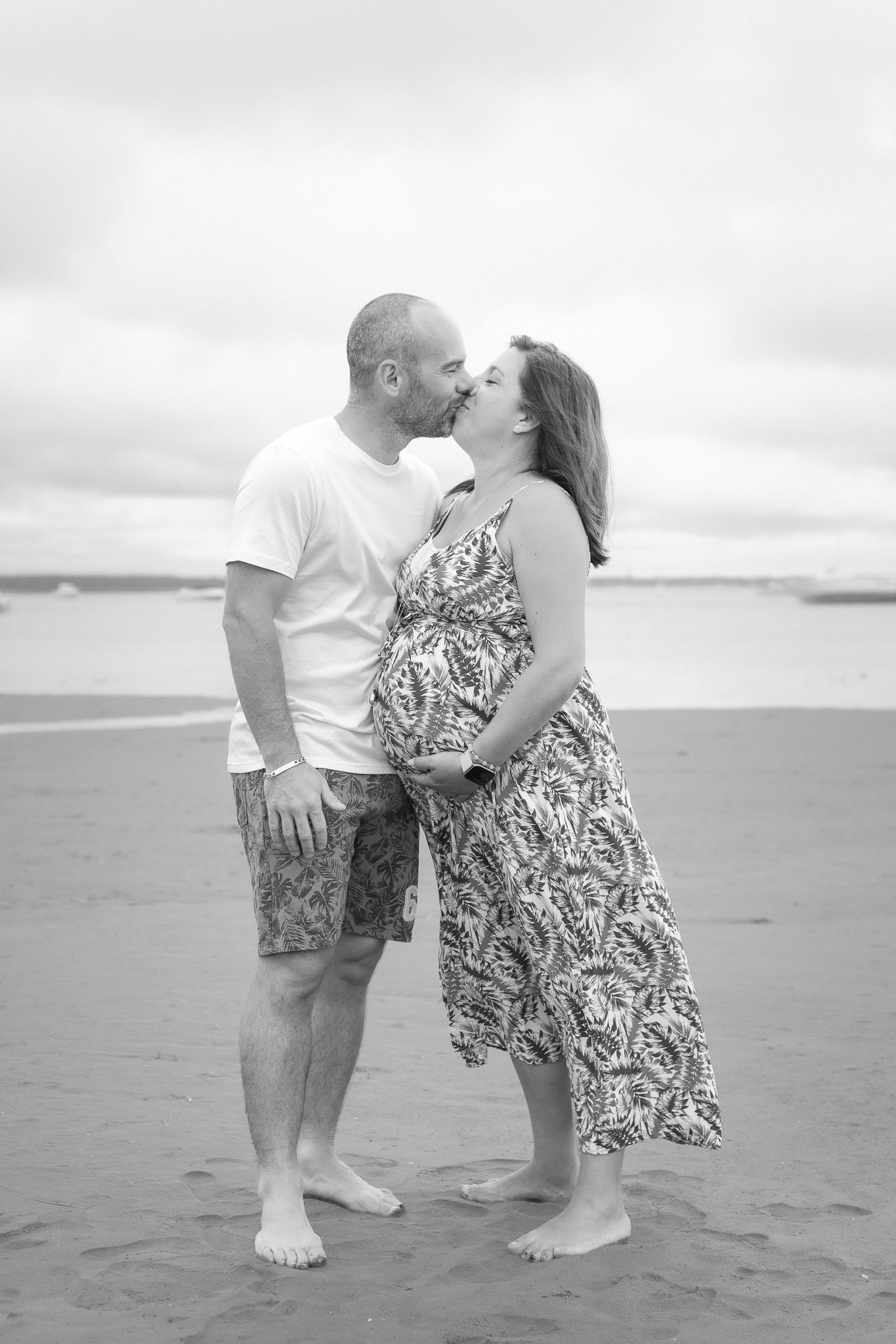 Couple enceinte enlacé sur la plage à Claouey, Cap Ferret