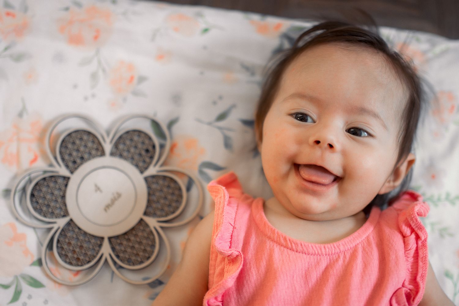 Portrait d'un bébé de 4 mois souriant, allongé sur le dos dans son lit à Langon, en Sud-Gironde