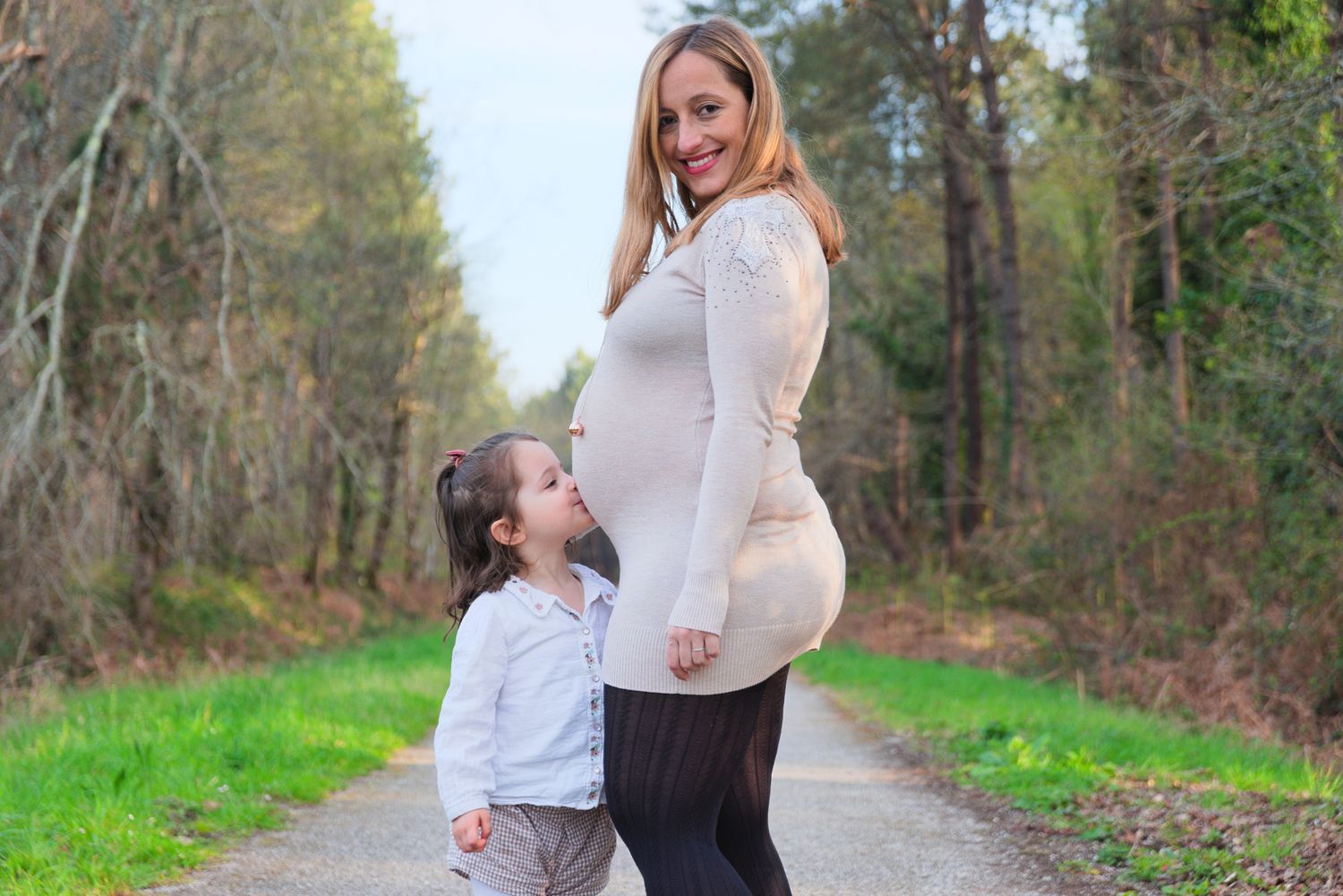 Petite fille embrassant le ventre de sa mère enceinte dans les bois du Nizan, près de Langon