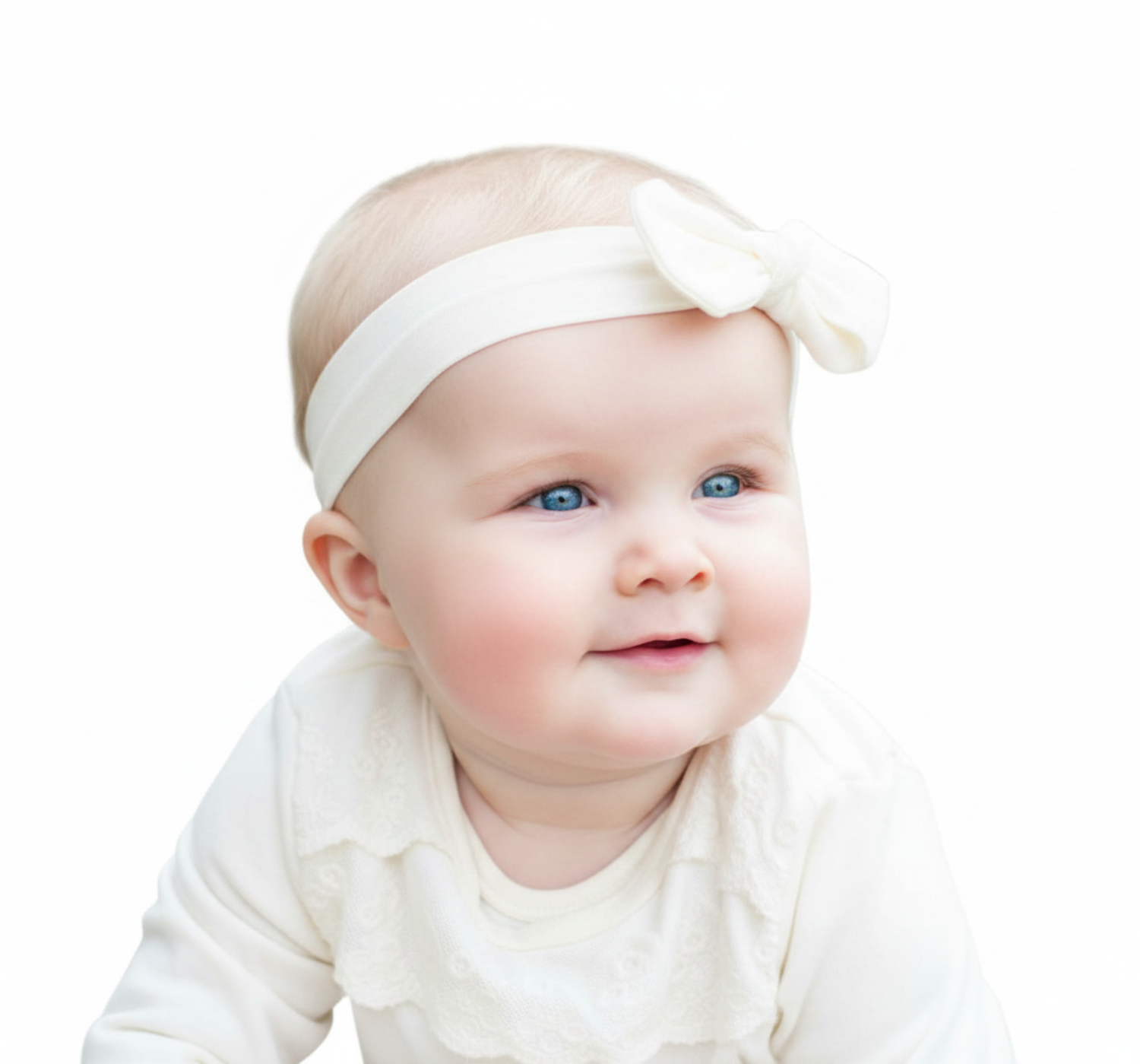 Adorable blue-eyed baby girl wearing a white bow headband and outfit, smiling against a white background.