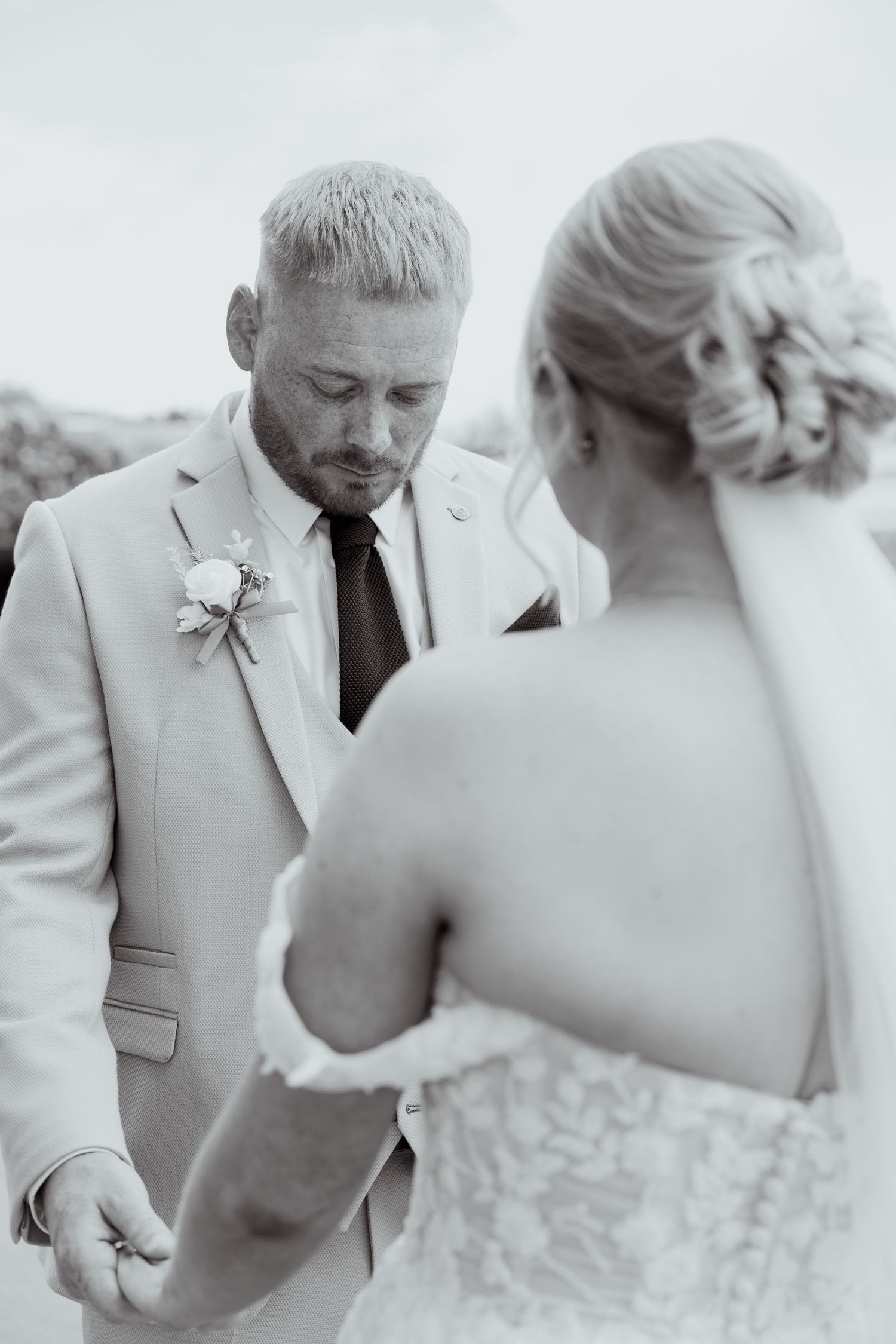 Black and white photo of groom holding bride's hands during emotional outdoor wedding ceremony vow exchange.
venue info ridgeway golf club