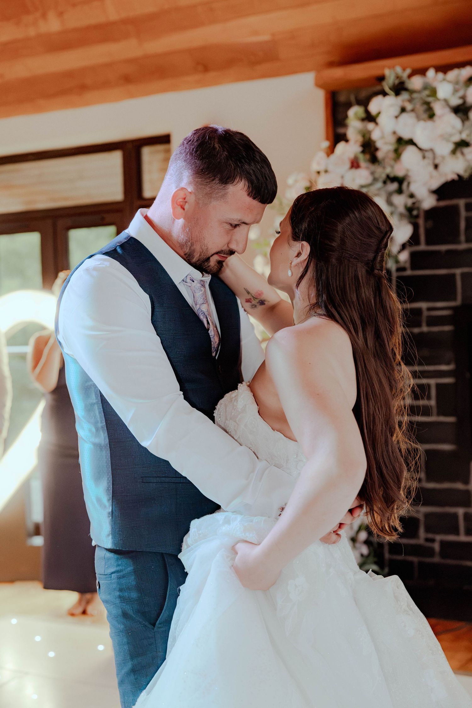 Bride and groom share intimate first dance moment with foreheads touching at wedding reception.