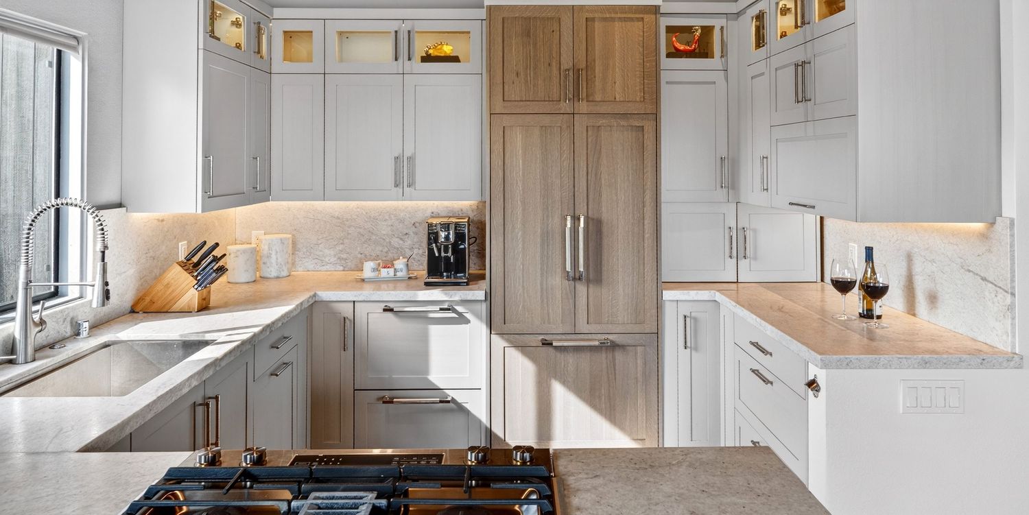 Bright white kitchen designed by interior designer in Sea Ranch wood pantry, marble countertops, subway tile backsplash, and gas range.