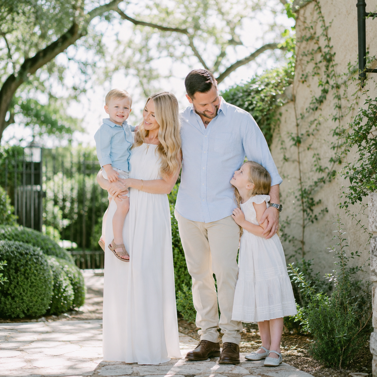 Family of four sharing a timeless portrait at Laguna Gloria in Austin, Texas surrounded by beautiful gardens.