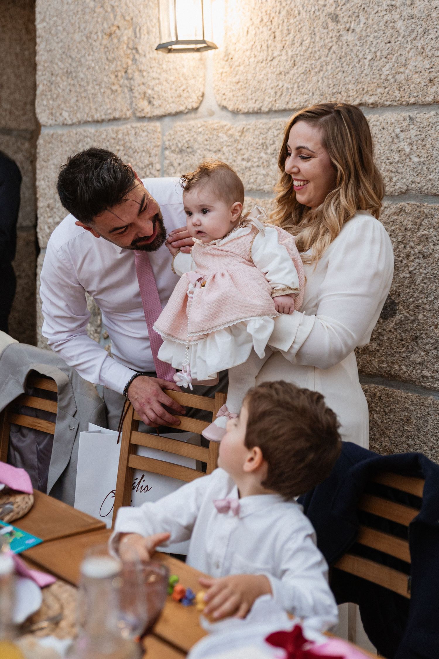 Família reúne-se em torno de bebé, num momento espontâneo e carinhoso durante a celebração do batizado da menina em Paredes.