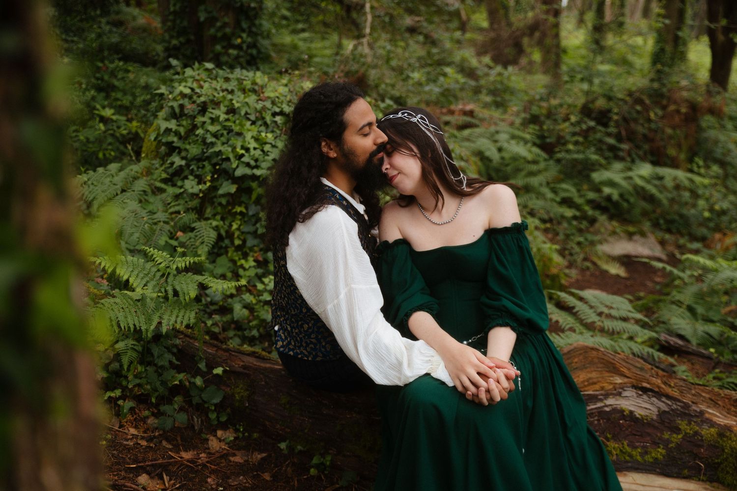 Casal abraçado e de mãos dadas numa floresta, com roupas inspiradas em fantasia e época medieval, em sessão no dia de casamento em Sintra.