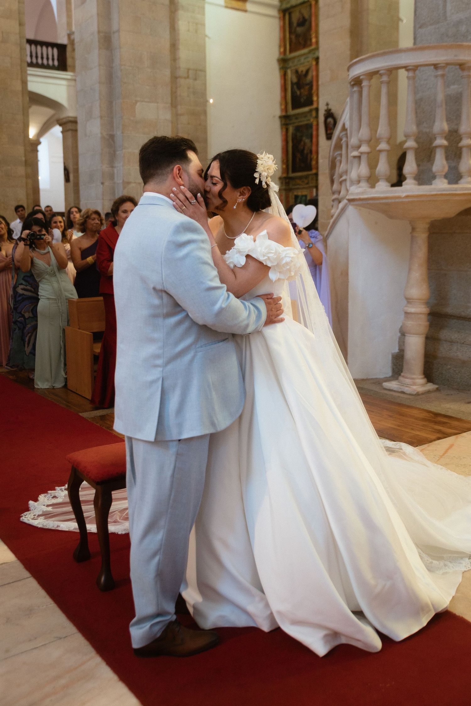 Noivos beijam-se e sorriem durante a cerimónia na Sé Catedral de Portalegre, num momento íntimo do dia do casamento.