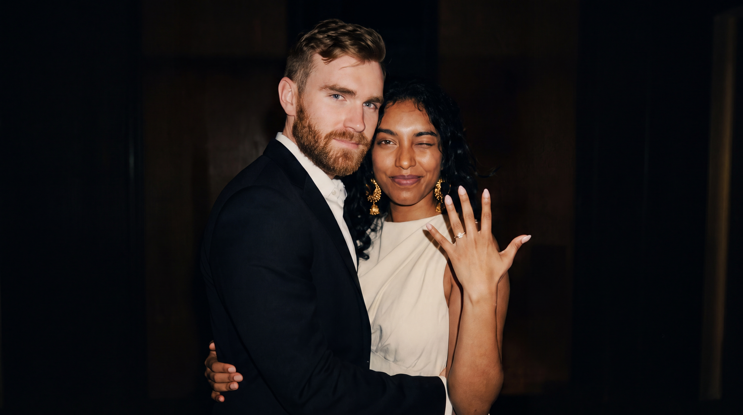 Newlyweds posing together as the bride displays her wedding ring.