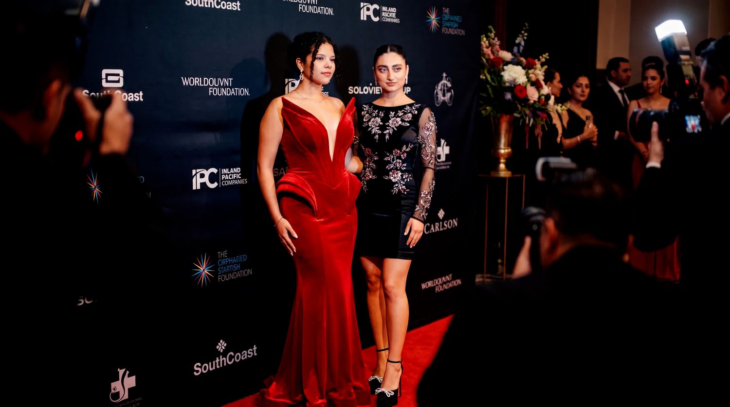 Two elegantly dressed women posing on the red carpet at a New York gala.