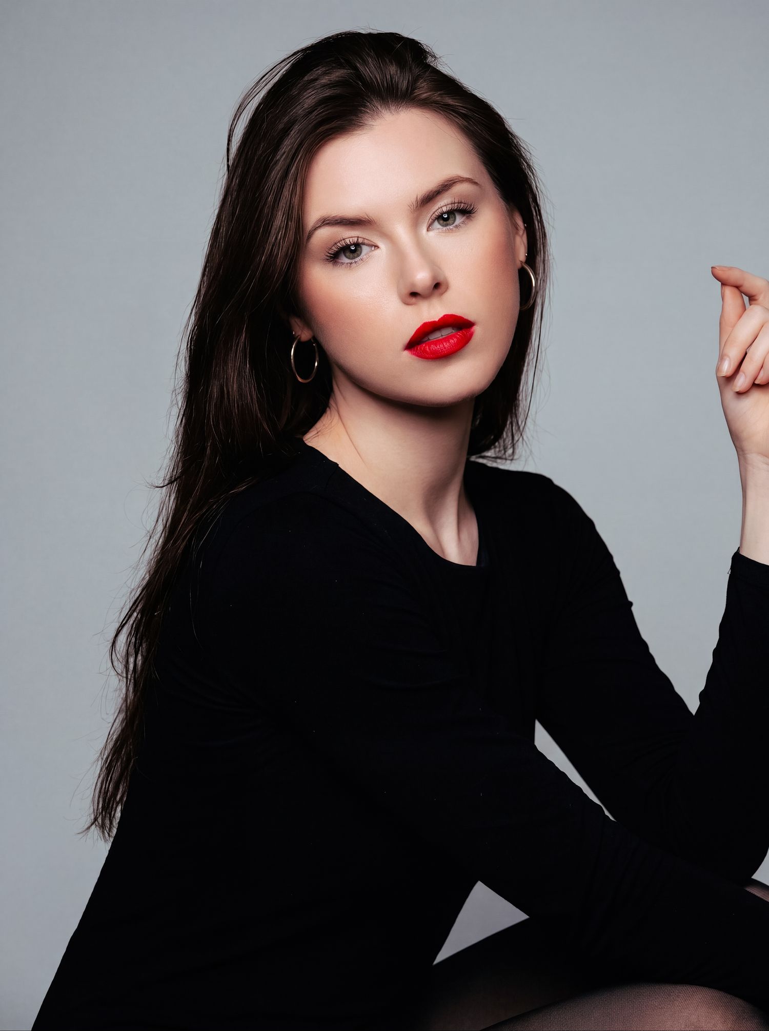 Fashion beauty portrait of a woman in black with bold red lipstick.