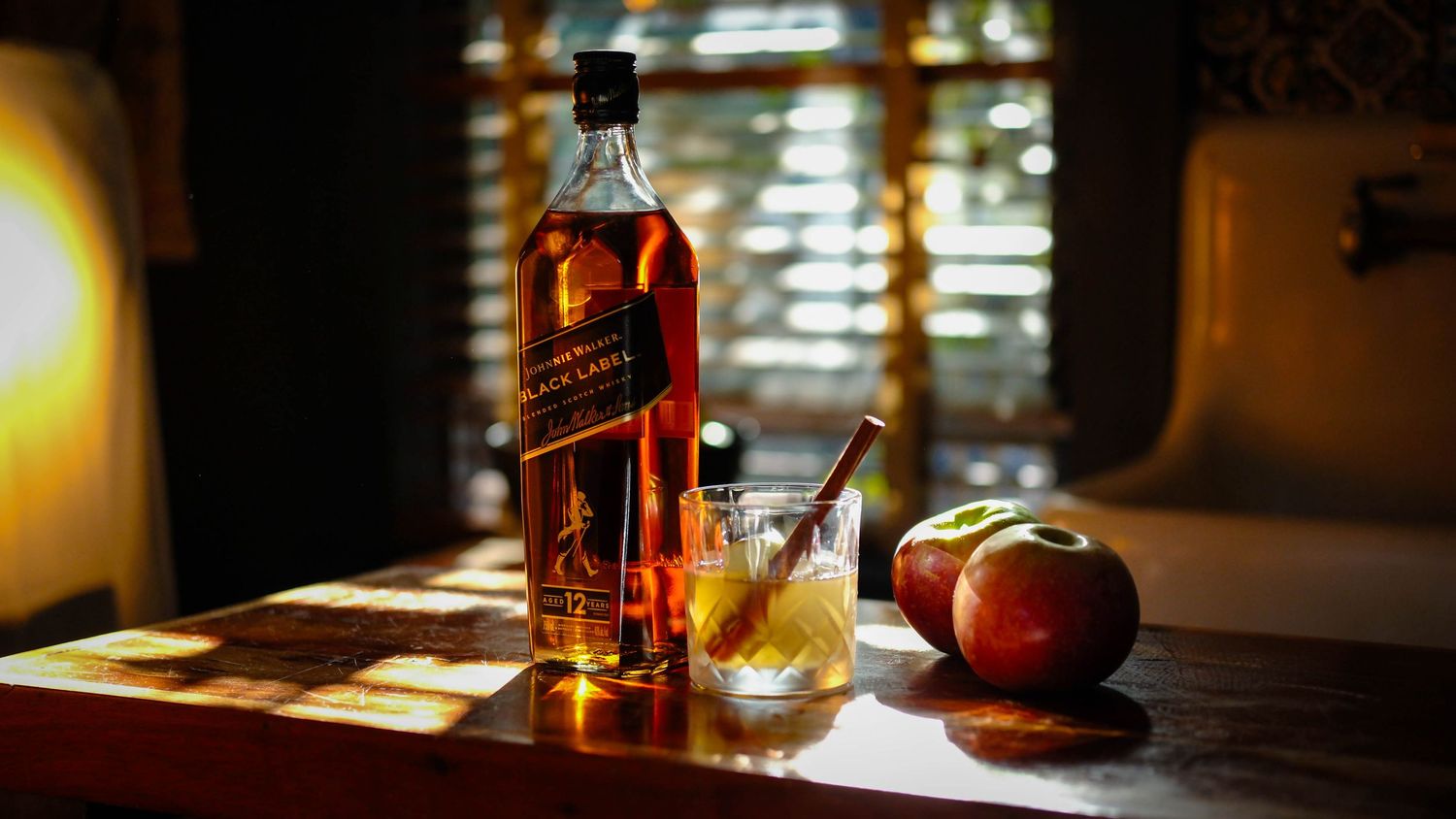 Johnnie Walker whisky and cocktail styled in warm window light.