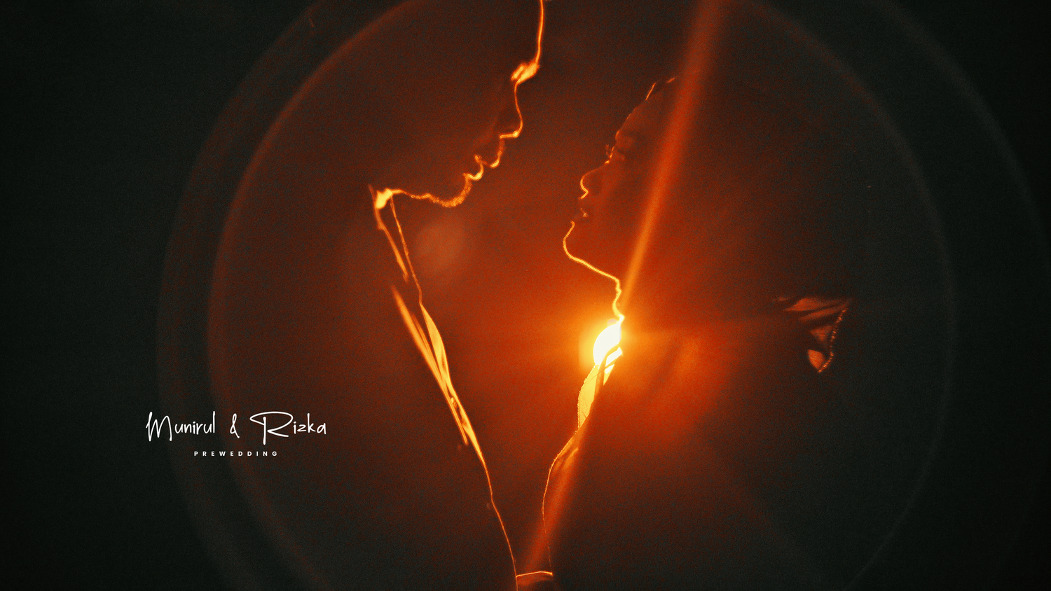 Romantic silhouette of two faces nearly kissing with glowing golden light between them against dark background.