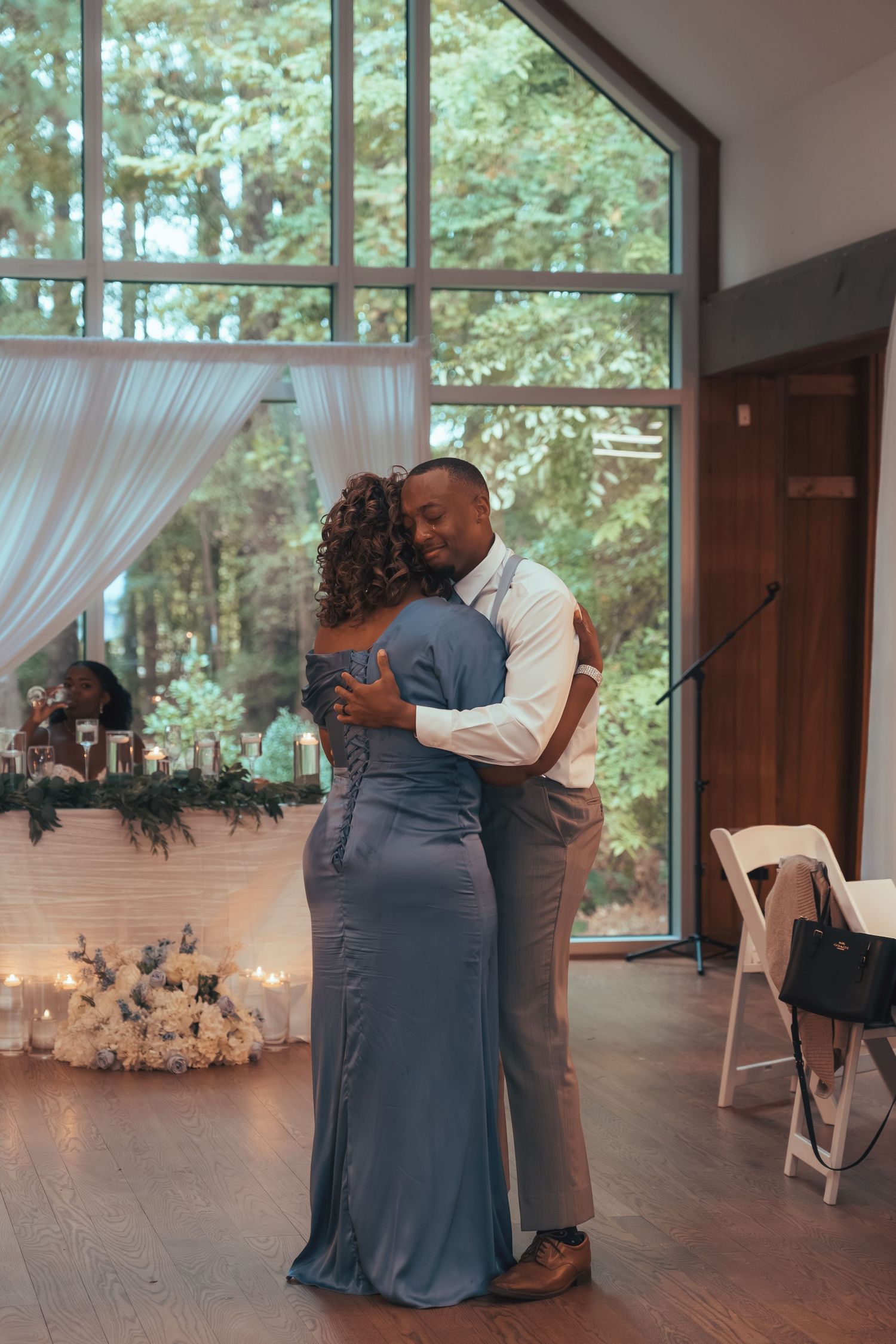 Groom shares emotional mother-son dance in elegant woodland reception venue.