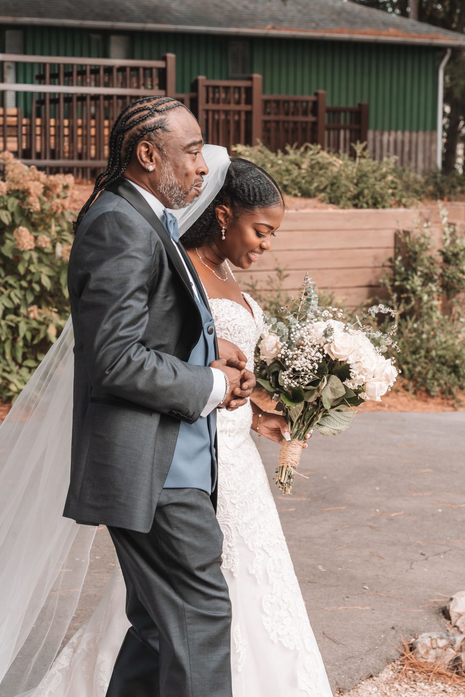 Father walking bride down the aisle with bouquet.