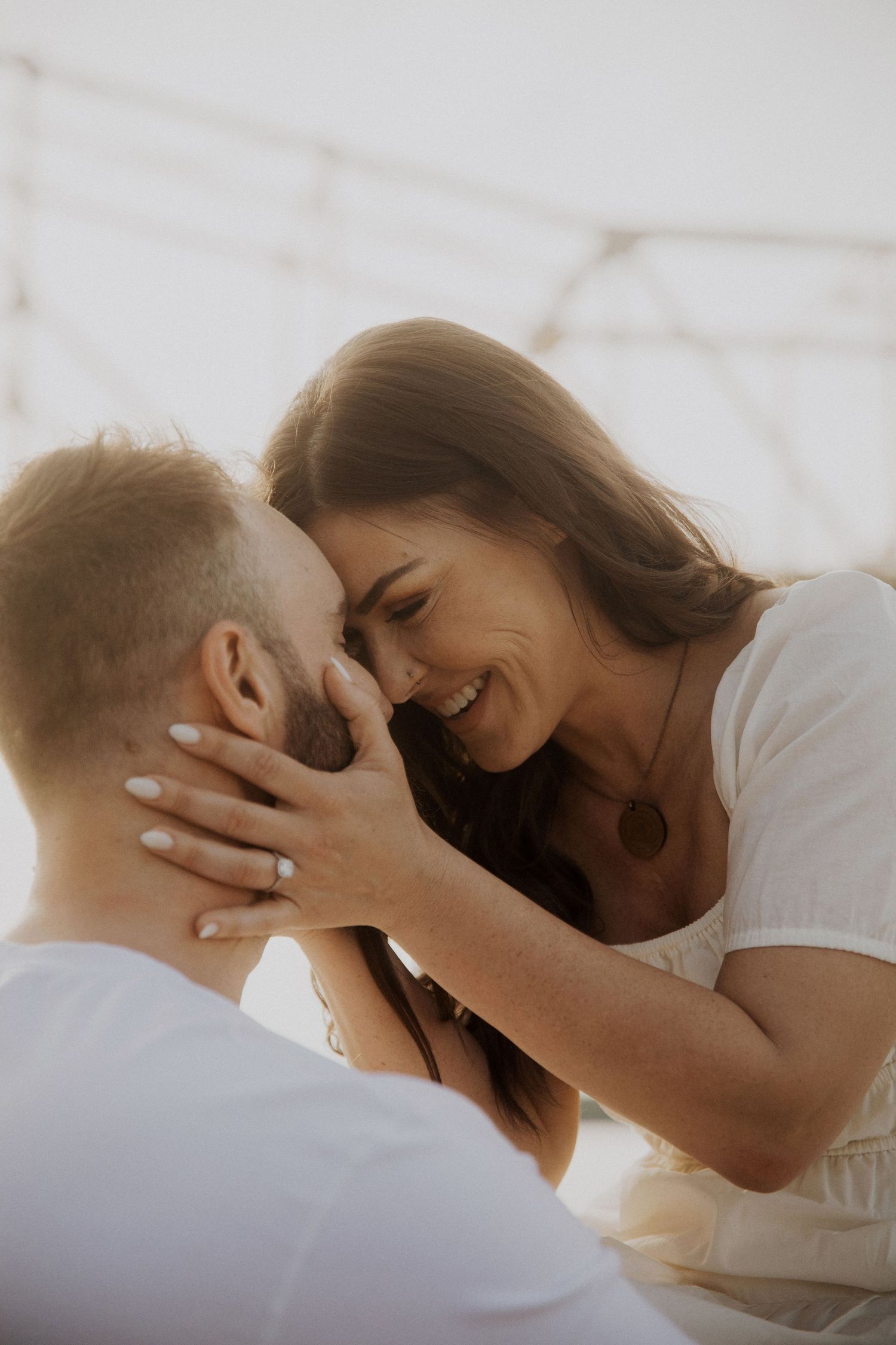 An intimate couple's portrait with natural lighting and joyful expressions.