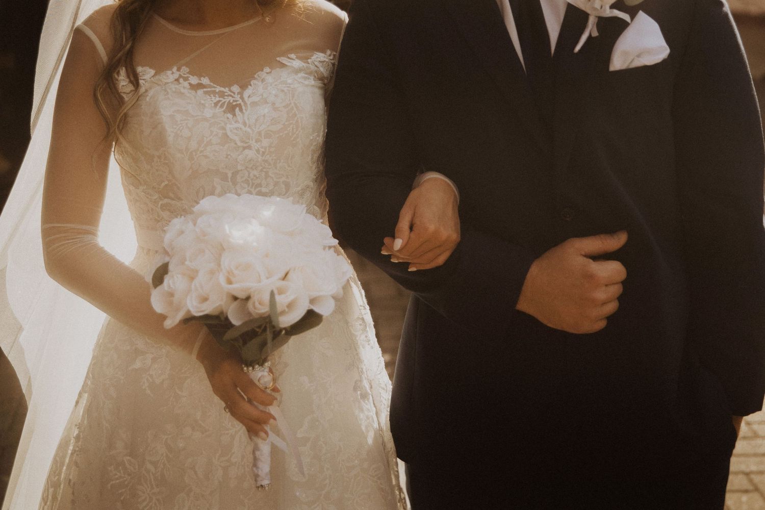 Romantic wedding couple moment captured in warm sepia tones.