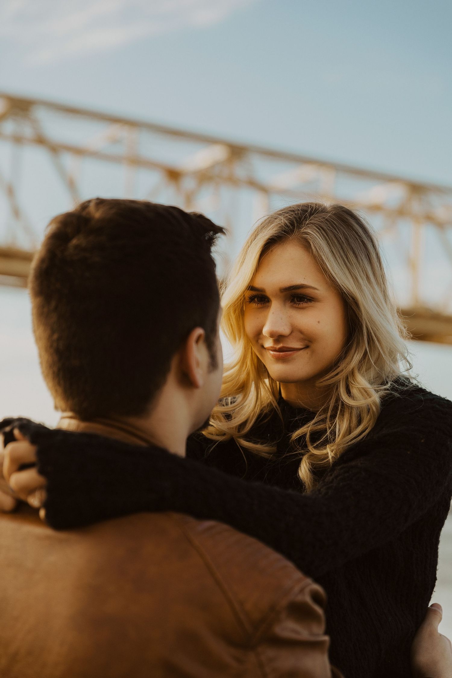 A series of intimate portraits showing a couple against an industrial background in warm light.