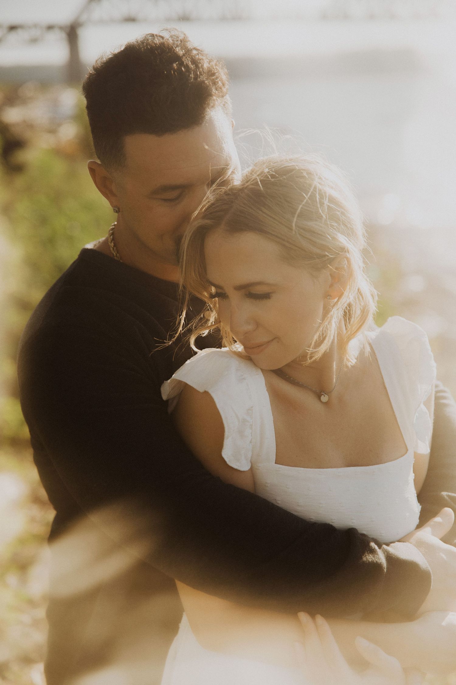 Intimate close-up of couple sharing tender moment in warm sunlight.