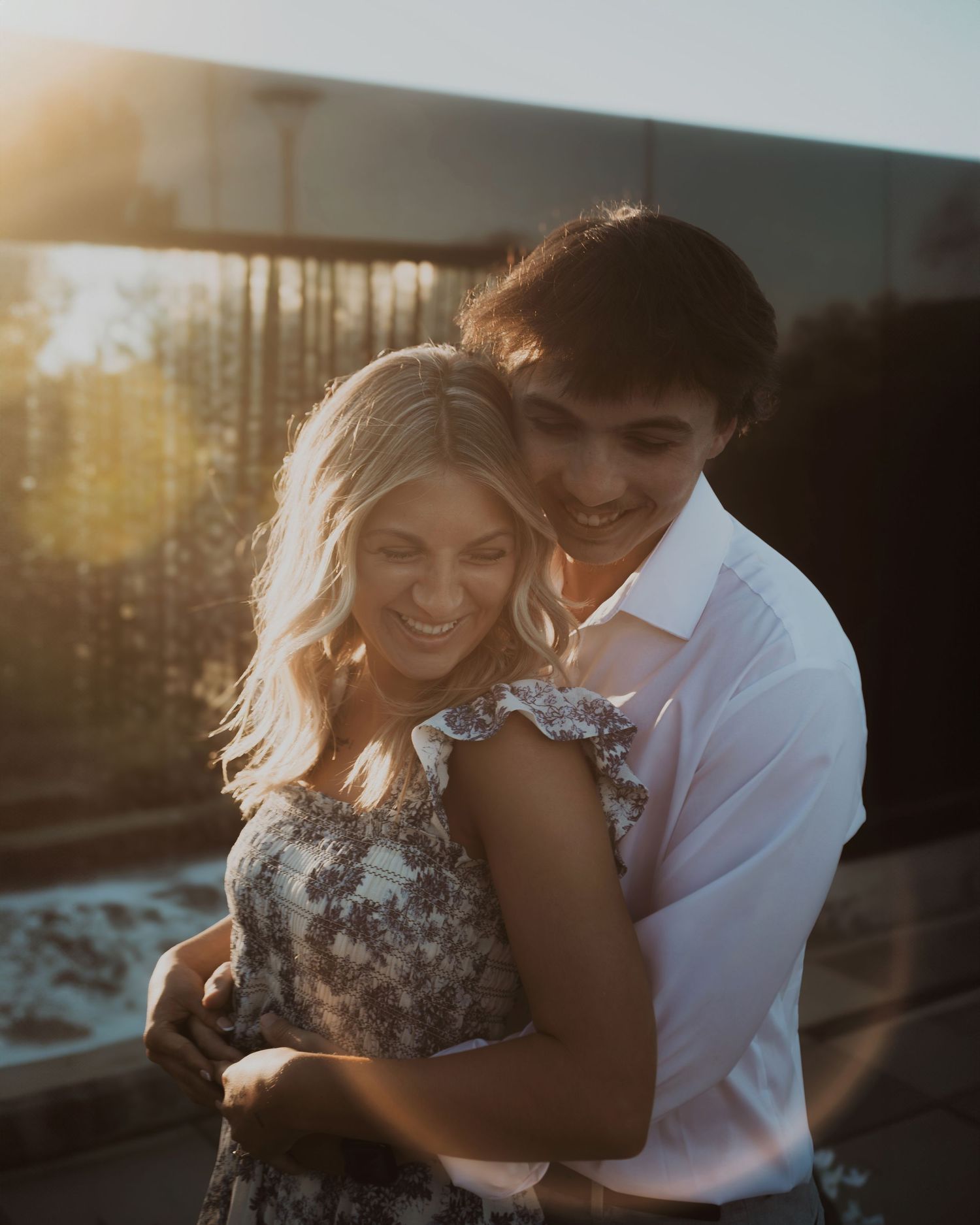 A romantic couple embraces during golden hour in a dreamy outdoor photoshoot.