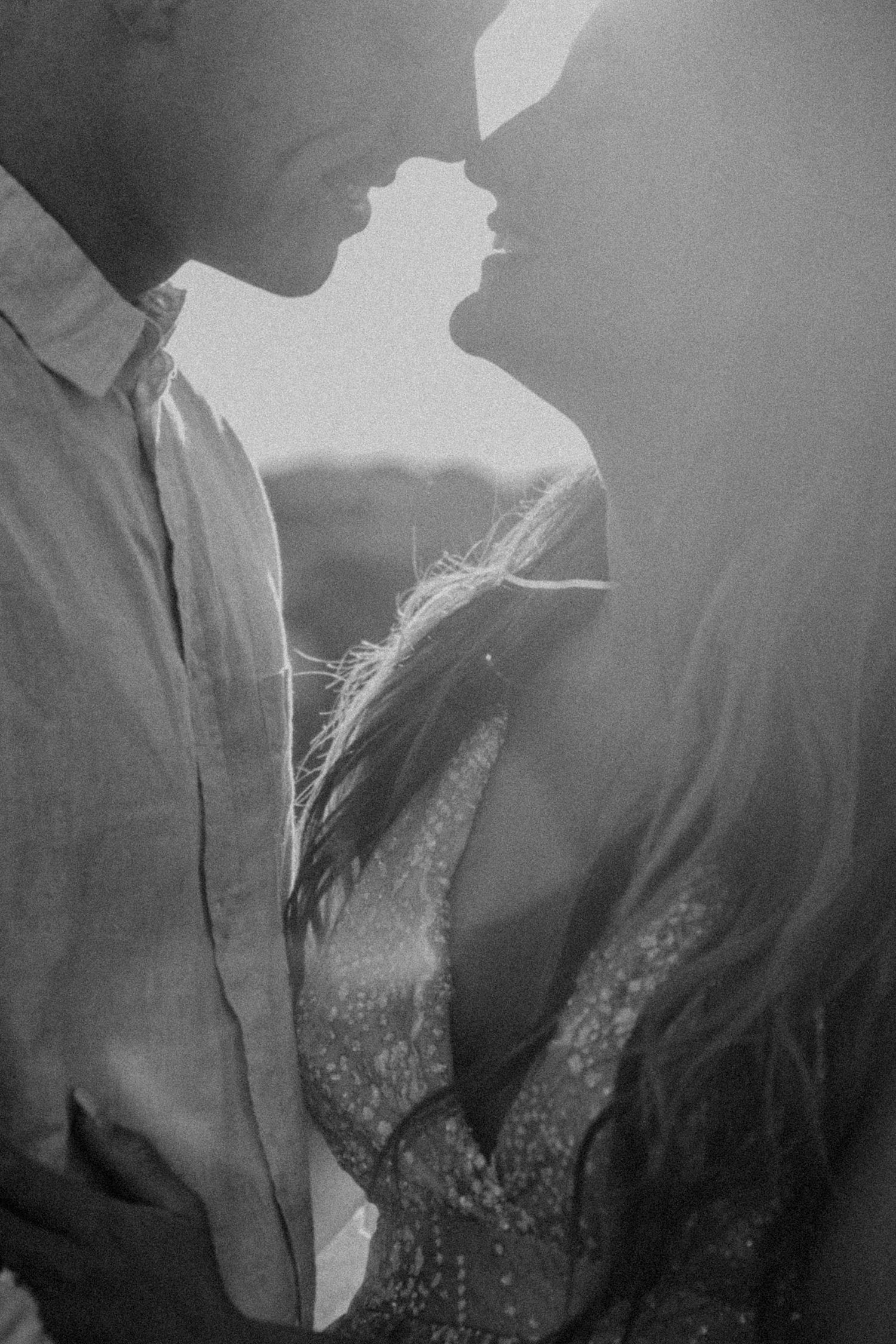 Artistic black and white silhouette of couple in intimate moment.