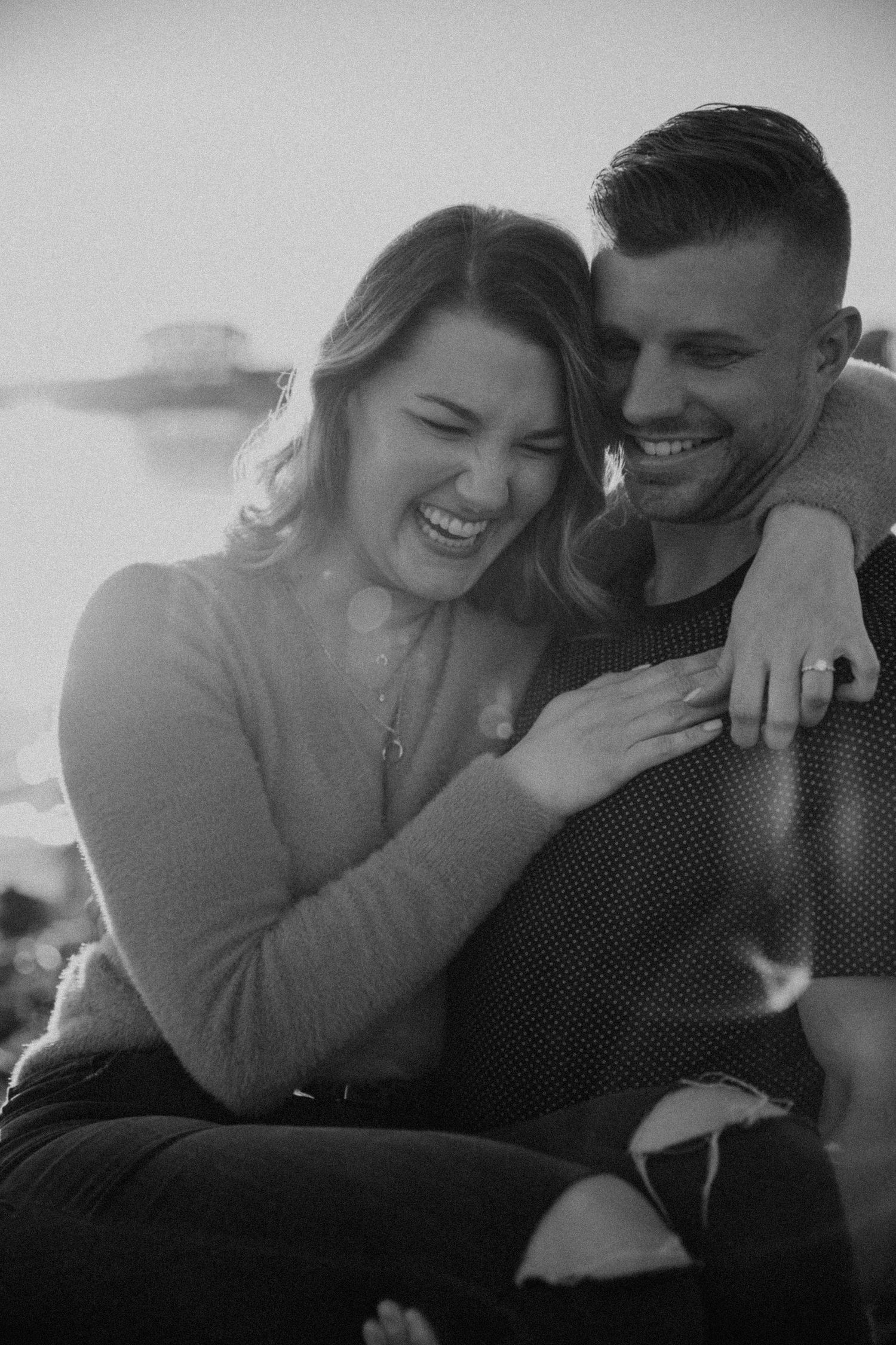 Black and white photos of a couple sharing candid laughing moments together.