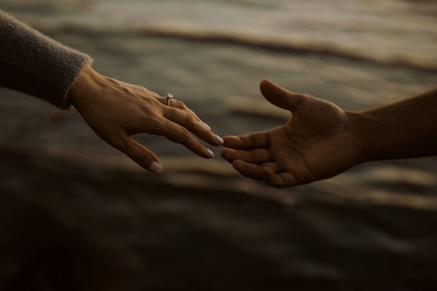 Artistic close-up shots of hands reaching toward each other.