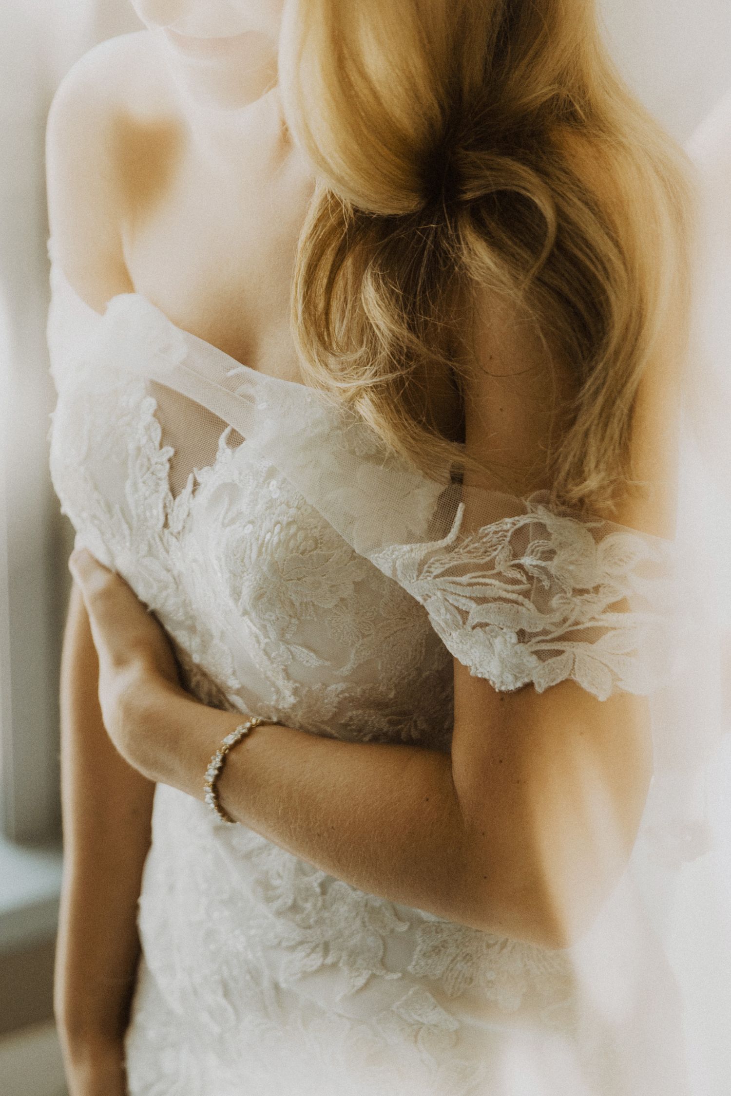Close-up details of delicate lace bodice on an ivory wedding gown.