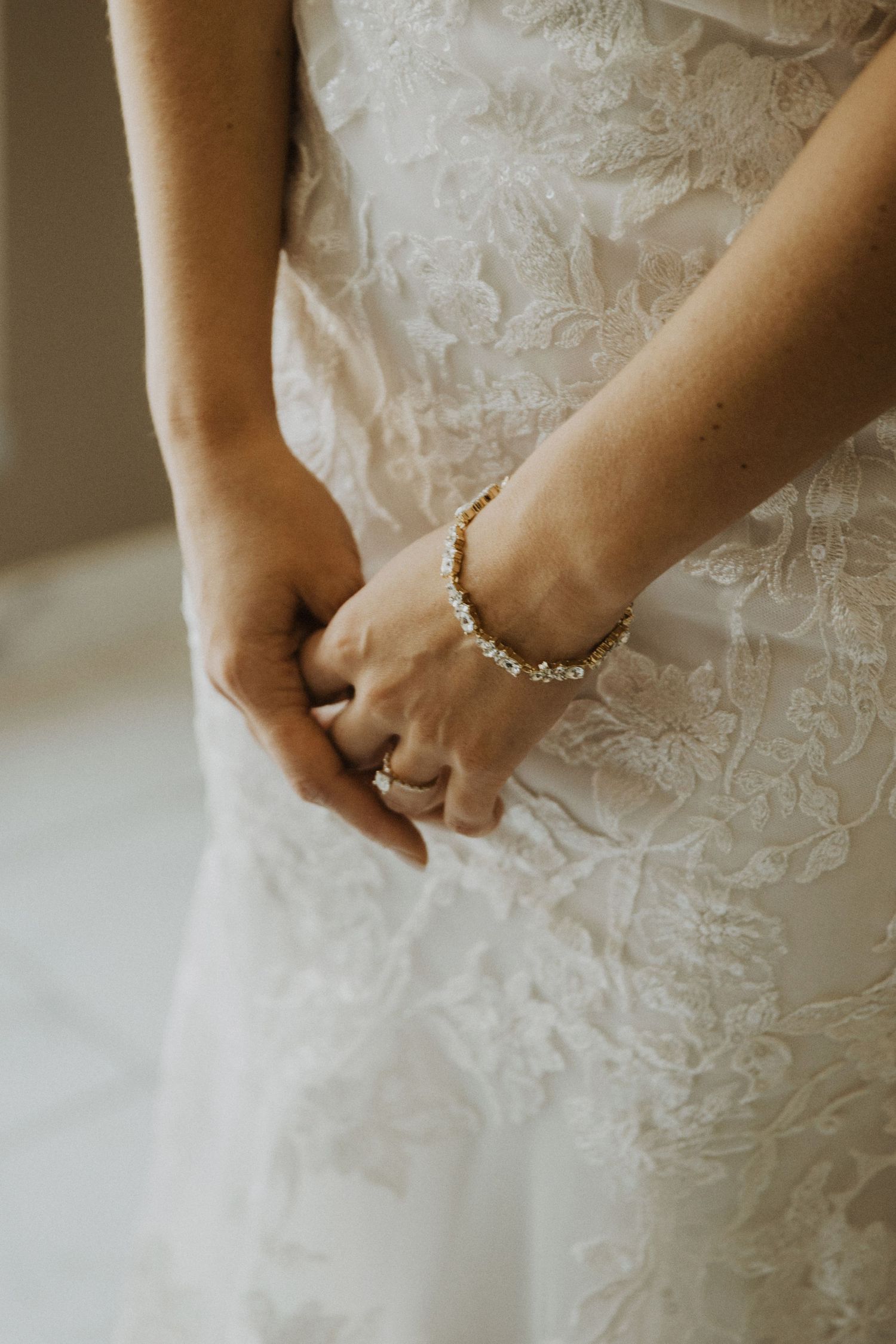 Detail shots of intricate lace wedding dress adjustments.