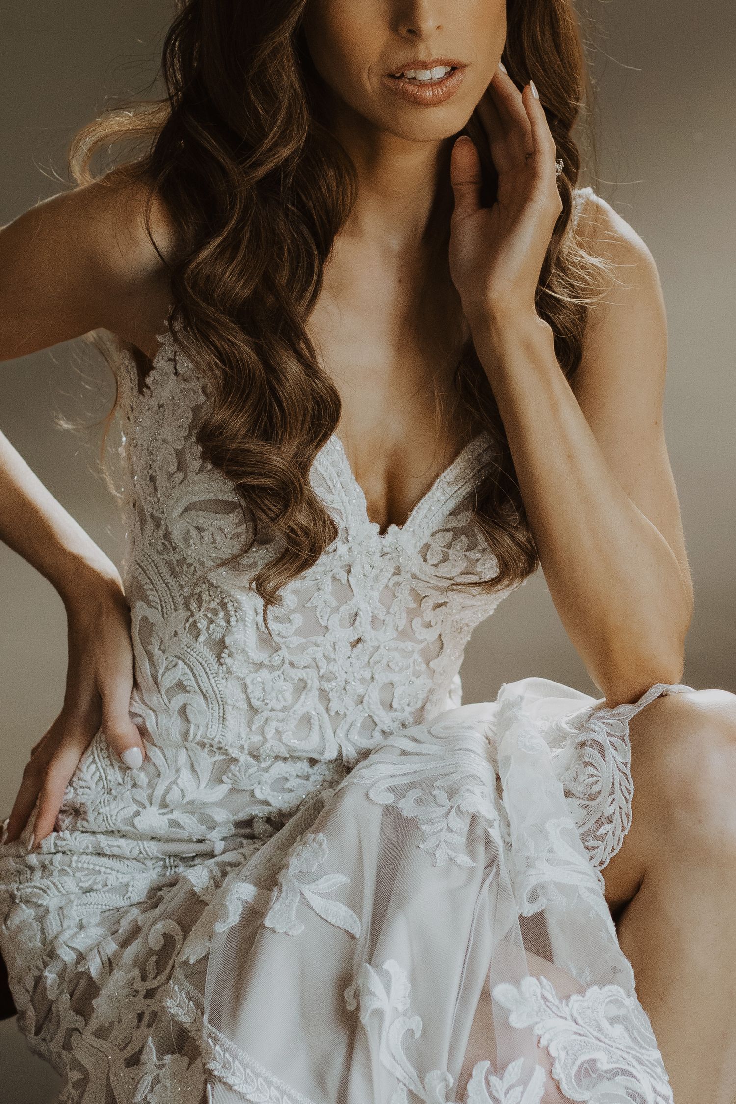 Close-up details of a white lace wedding dress bodice with intricate floral patterns.