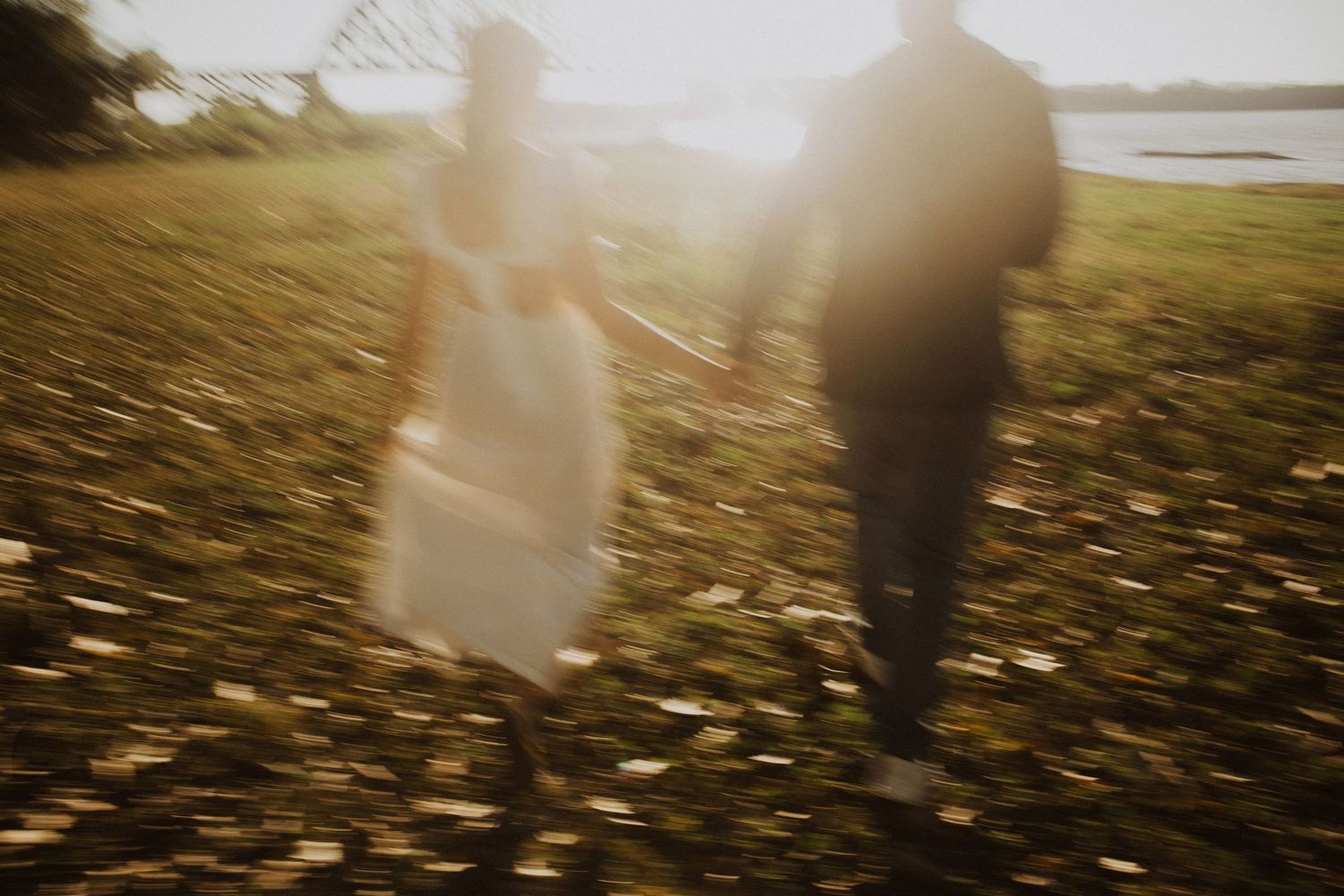 Couple's silhouettes merge in misty golden light during outdoor session.
